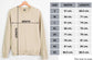 Beige sweatshirt on a hanger with size chart on a white background